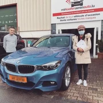 Zwei MKAA-Kunden mit ihrem blauen BMW 3er GT vor der Filiale Bertrange