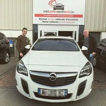 Zwei zufriedene Kunden mit ihrem weissen Opel Insignia OPC vor der MKAA-Filiale